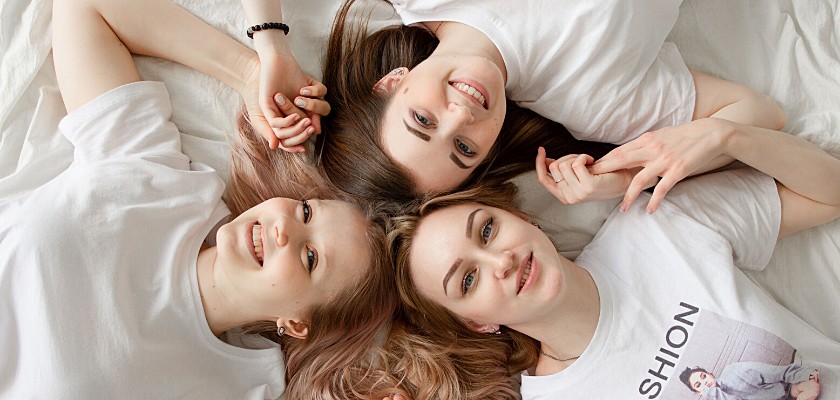 3 donne che sorridono distese a letto
