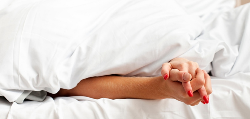 Uomo e donna che si tengono per mano dietro le lenzuola – Orgasmo multiplo femminile