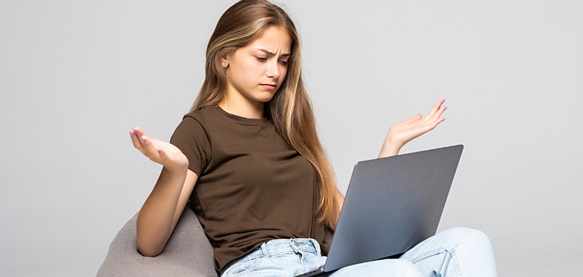Vista laterale di una donna depressa e frustrata che lavora con il computer portatile